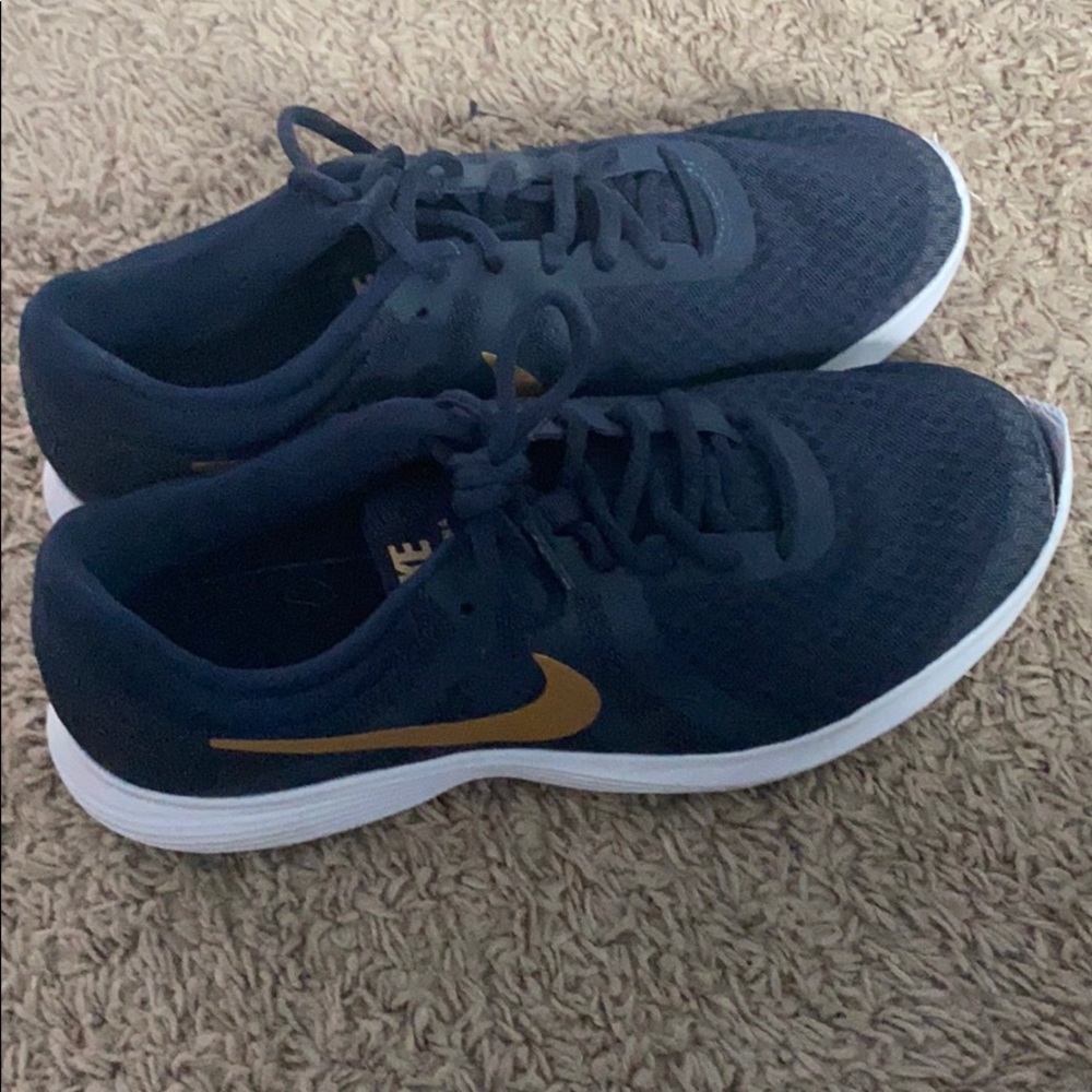 Blue Nike shoes with golden Nike swoop